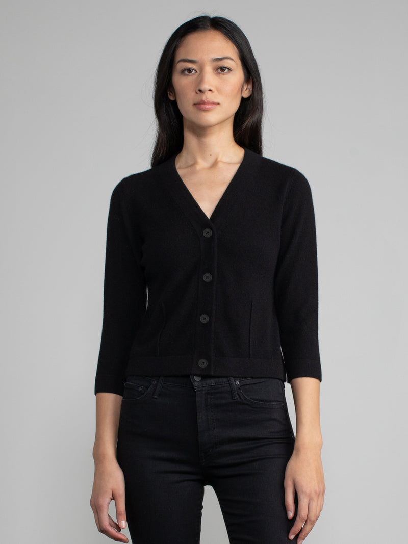 Woman wearing a black cropped cashmere cardigan.