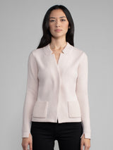 Woman wearing a fitted light pink cashmere jacket.