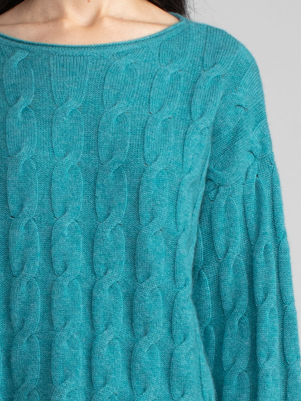 Woman wearing the Shirttail Cable Pullover in emerald.