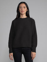 Female wearing black waffle stitched pullover.