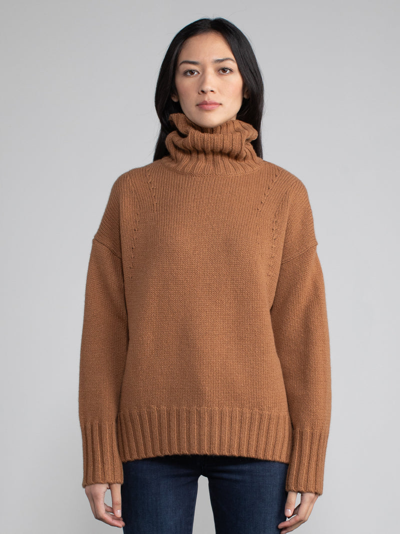 Woman wearing brown turtleneck sweater.