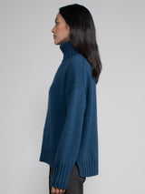 Woman wearing blue turtleneck sweater.