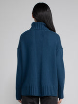 Woman wearing blue turtleneck sweater.