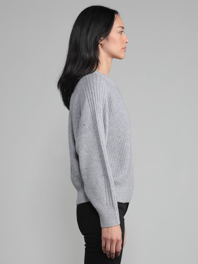Woman wearing grey sweatshirt.