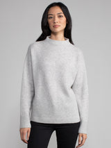 Woman wearing a grey cashmere sweater.