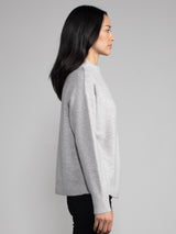 Woman wearing a grey cashmere sweater.