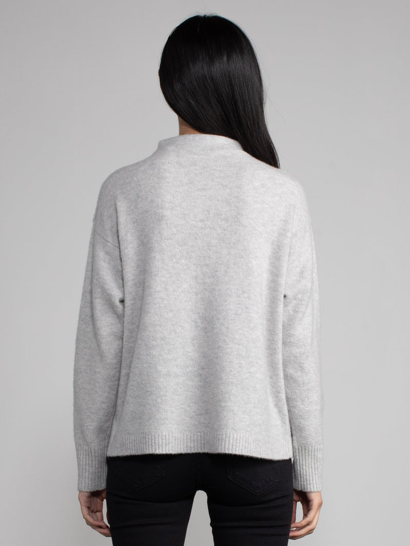 Woman wearing a grey cashmere sweater.