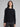 Woman wearing a black ribbed knit sweater.