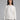 Woman wearing a white ribbed knit sweater.
