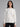 Woman wearing a white ribbed knit sweater.