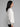 Woman wearing a white ribbed knit sweater.