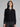 Woman wearing a black polo cardigan sweater.