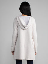 Woman in a white and grey, long line hooded cardigan.