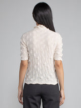 Back view of the model wearing the eggshell elbow tneck and a pair of pants.
