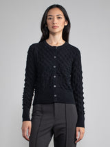 Model wearing a black cardigan with button closure.