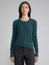 Model wearing a green cardigan with button closure.