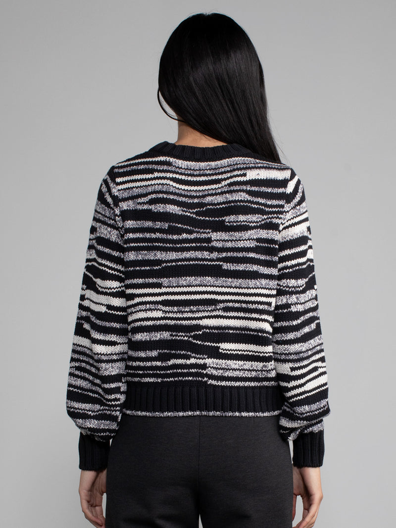 Woman wearing a wavy striped sweater.