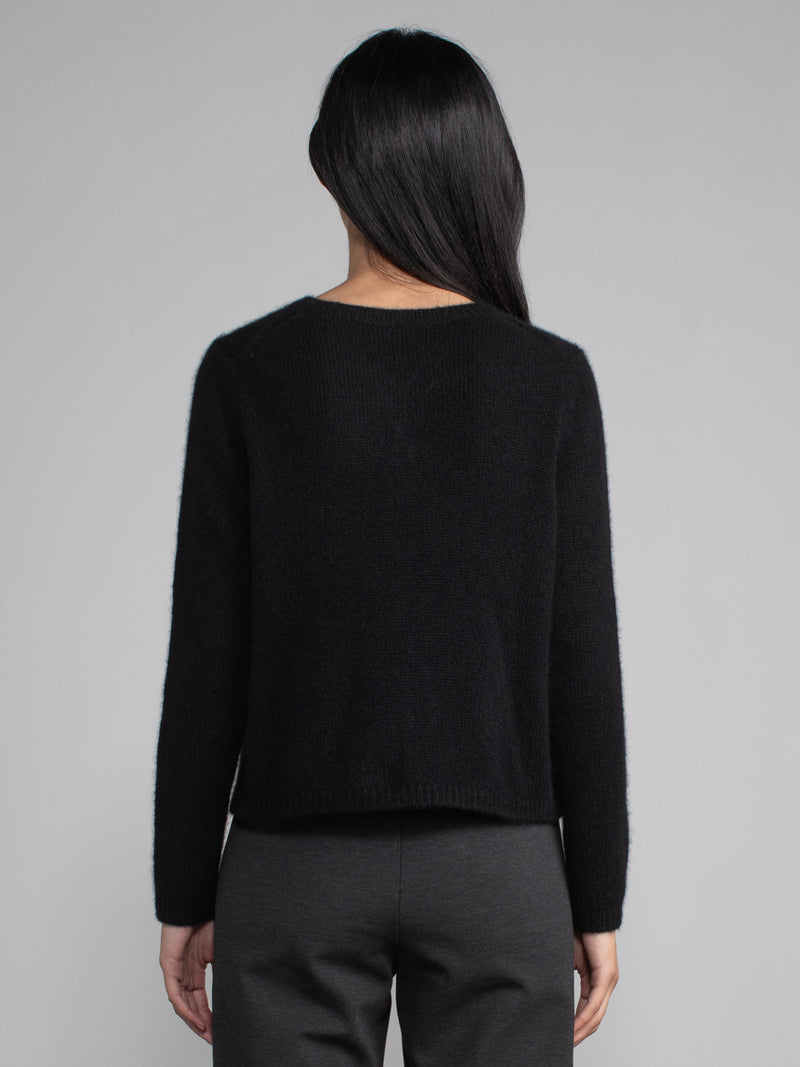 Back view of model wearing black cashmere cardigan.