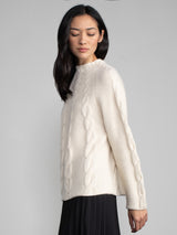 Woman wearing a white cashmere and alpaca sweater.