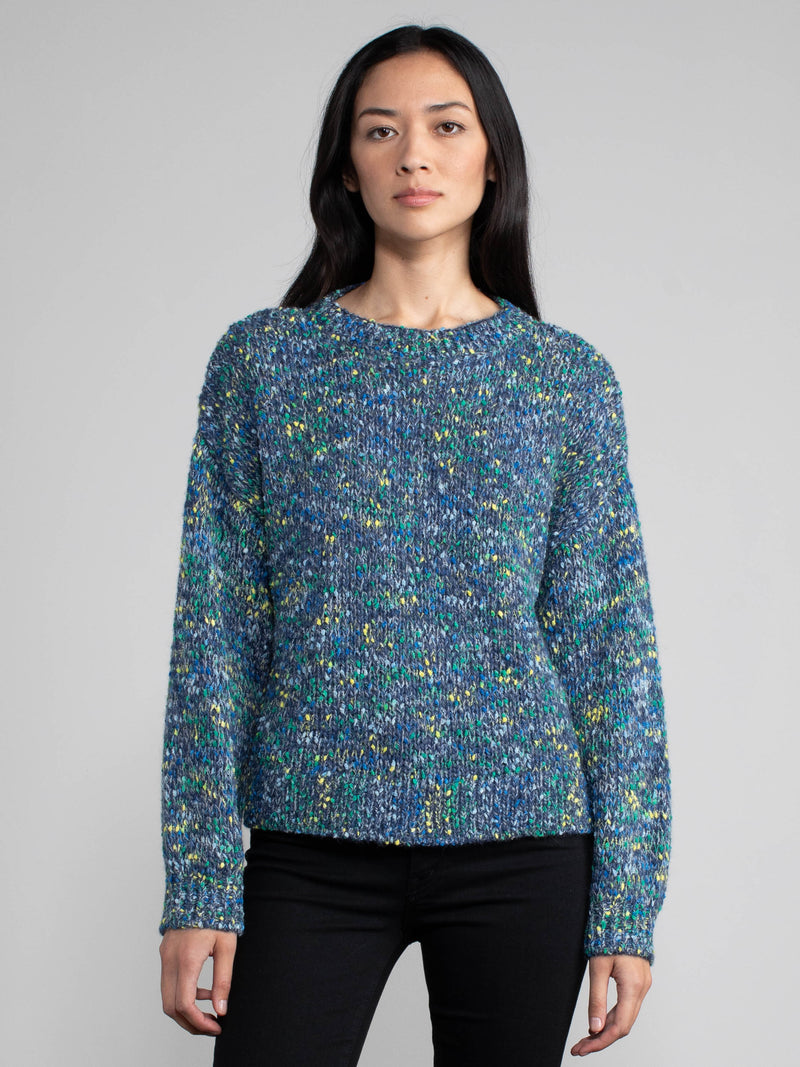 Woman wearing a blue speckled knit sweater.