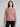 Woman wearing a red speckled knit sweater.