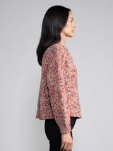 Woman wearing a red speckled knit sweater.