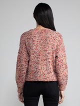 Woman wearing a red speckled knit sweater.