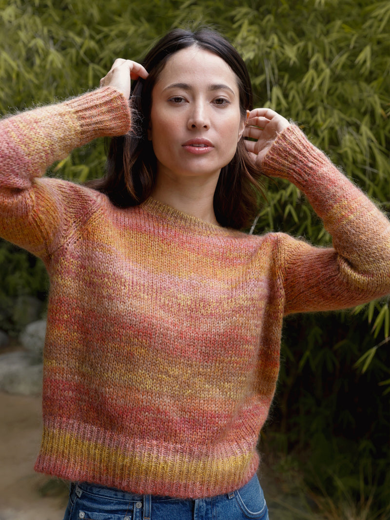 Woman wearing an orange and red knit sweater.