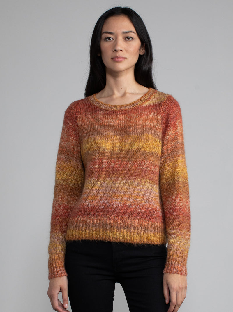Woman wearing an orange and red knit sweater.