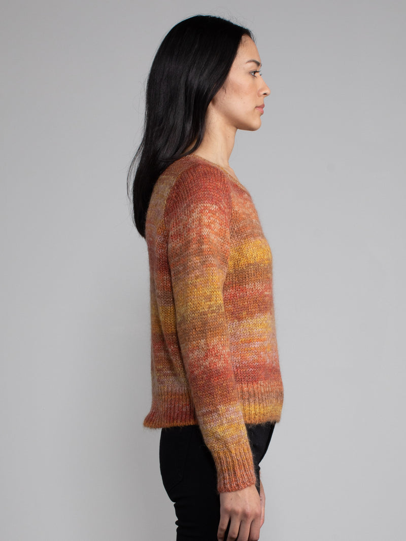 Woman wearing an orange and red knit sweater.