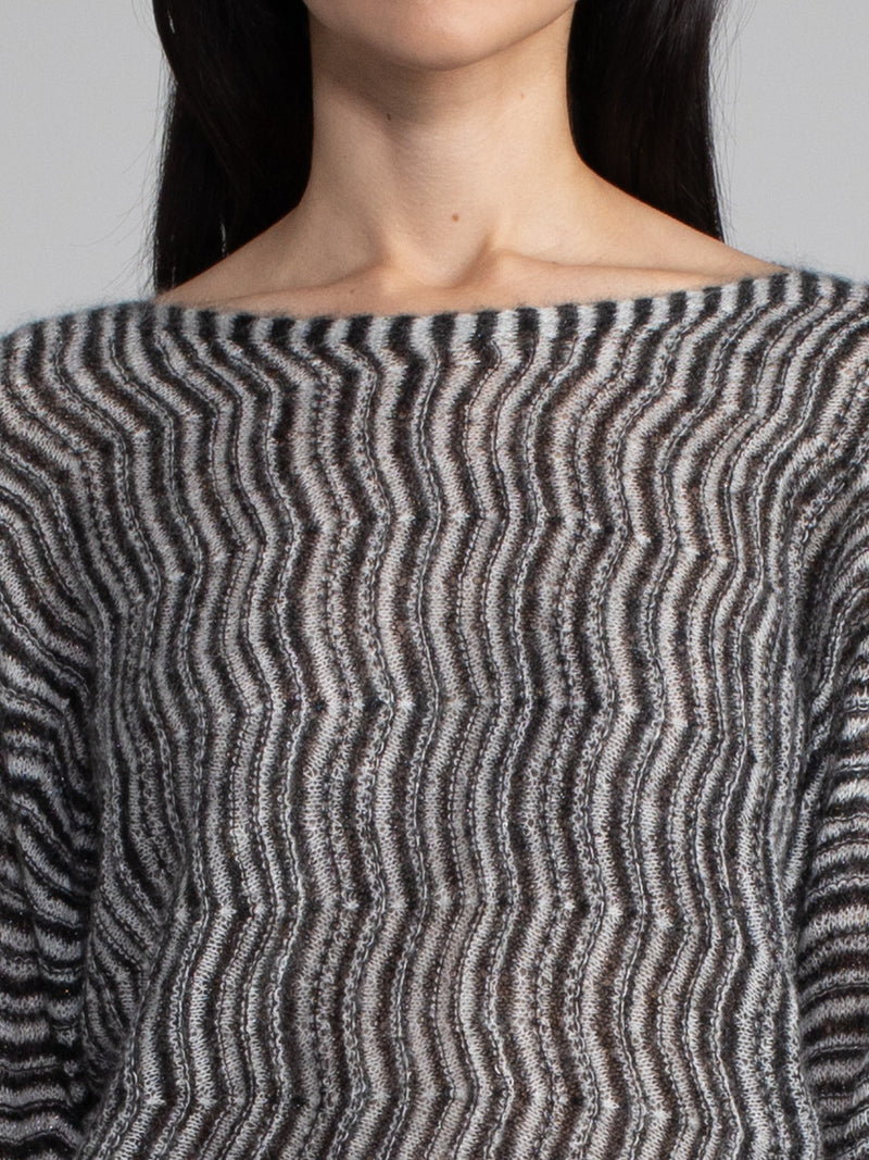 Female wearing a black and white boatneck top.