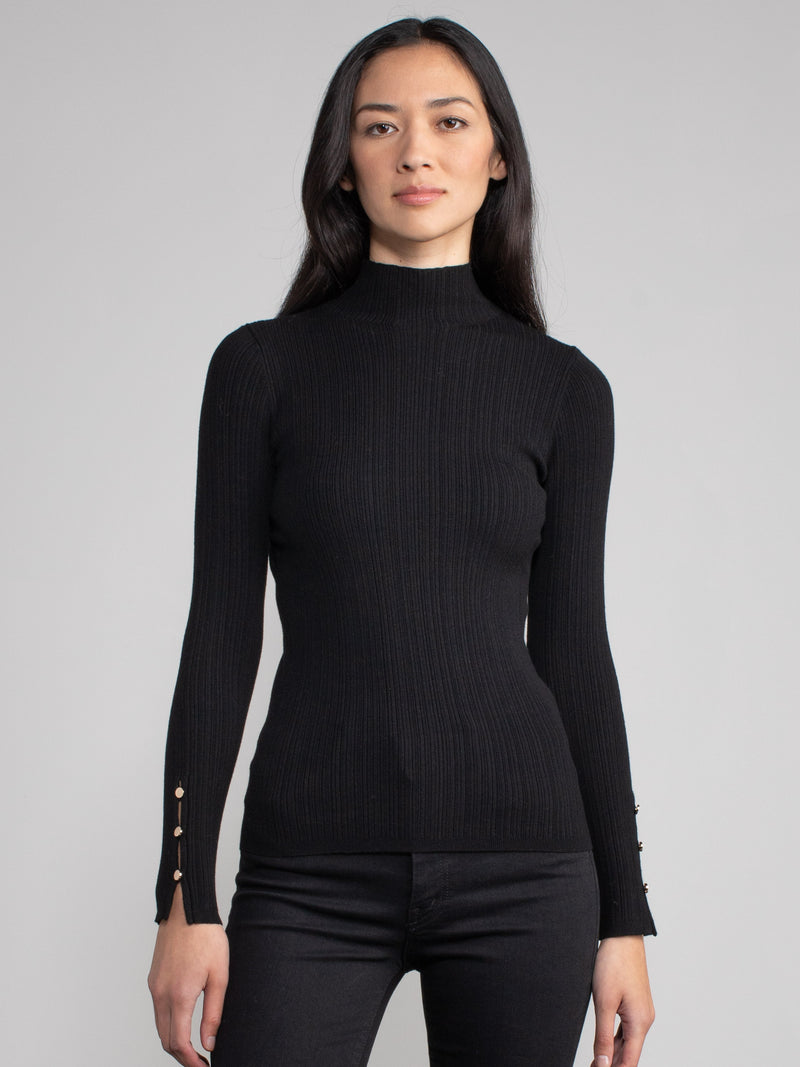 Woman wearing a fitted black turtleneck.