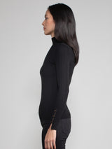 Woman wearing a fitted black turtleneck.