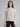 Woman wearing a grey cable knit sweater.
