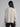 Woman wearing a grey cable knit sweater.