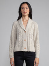 Woman wearing a grey cable knit cardigan.