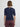 Person wearing a navy blue short-sleeve top with a cut-out back design on a plain background