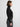 Woman wearing a black turtleneck sweater and gray pants on a white background