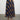 Woman wearing the Natalya Pleated Skirt by Margaret O’Leary, a multicolor plaid pleated midi skirt on a plain background.