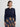 Woman wearing a navy cardigan over a plaid skirt on a plain background