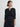 Woman wearing a black cardigan over a black dress on a white background