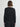 Person wearing a black cardigan and skirt set on a plain background