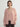 Woman wearing a pale pink cashmere open front cardigan, with four buttons, layered over a pale pink cashmere cardigan by Margaret O'Leary