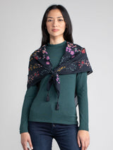 Woman wearing a floral scarf around her as a shawl.