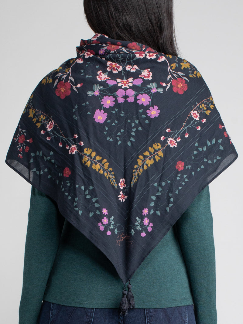Woman wearing a floral scarf around her as a shawl.