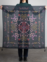 Woman holding a sheer floral scarf.