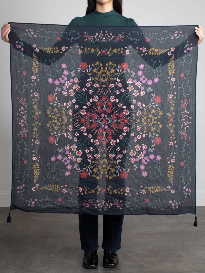 Woman holding a sheer floral scarf.