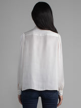 Female wearing white blouse with tie neck