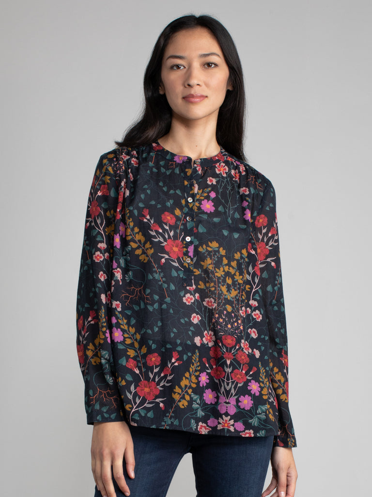 Woman wearing a dark floral henley top.