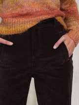 Woman wearing brown corduroy pants.